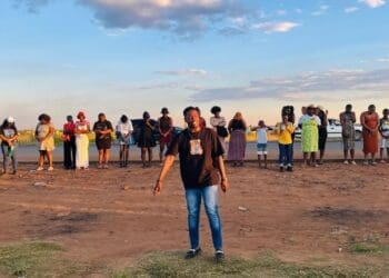 Lwazi Mnisi, a resident of Lawley, leads the prayer at R558 and Walter Road intersection (Image: Viki Stuurman)
